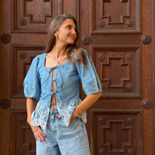 Woman wearing a blue denim outfit in front of a wooden door