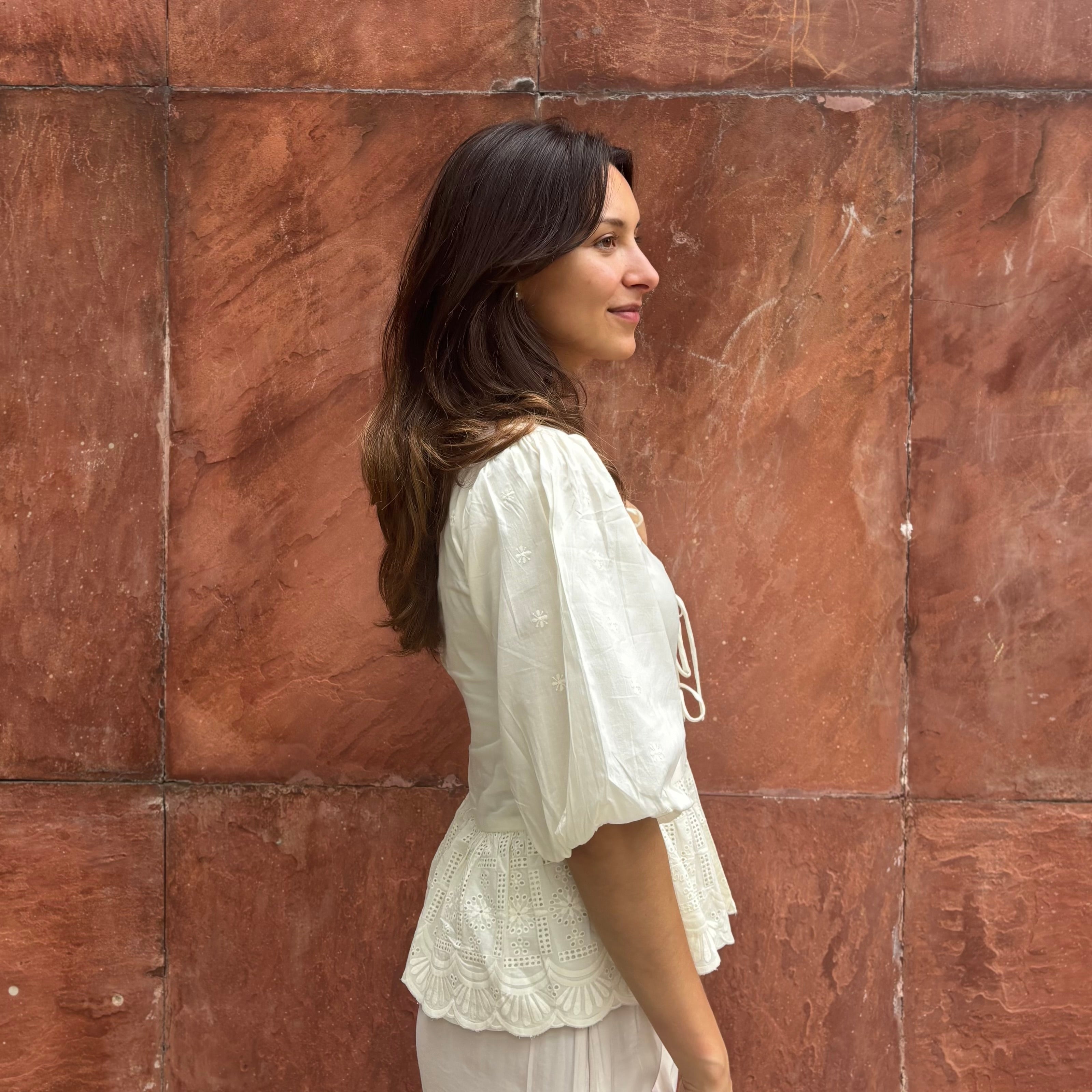 Cotton blouse with subtle chikankari embroidery, puff sleeves, and bow-tie neckline. Handcrafted in small batches by artisans in India for effortless slow fashion.